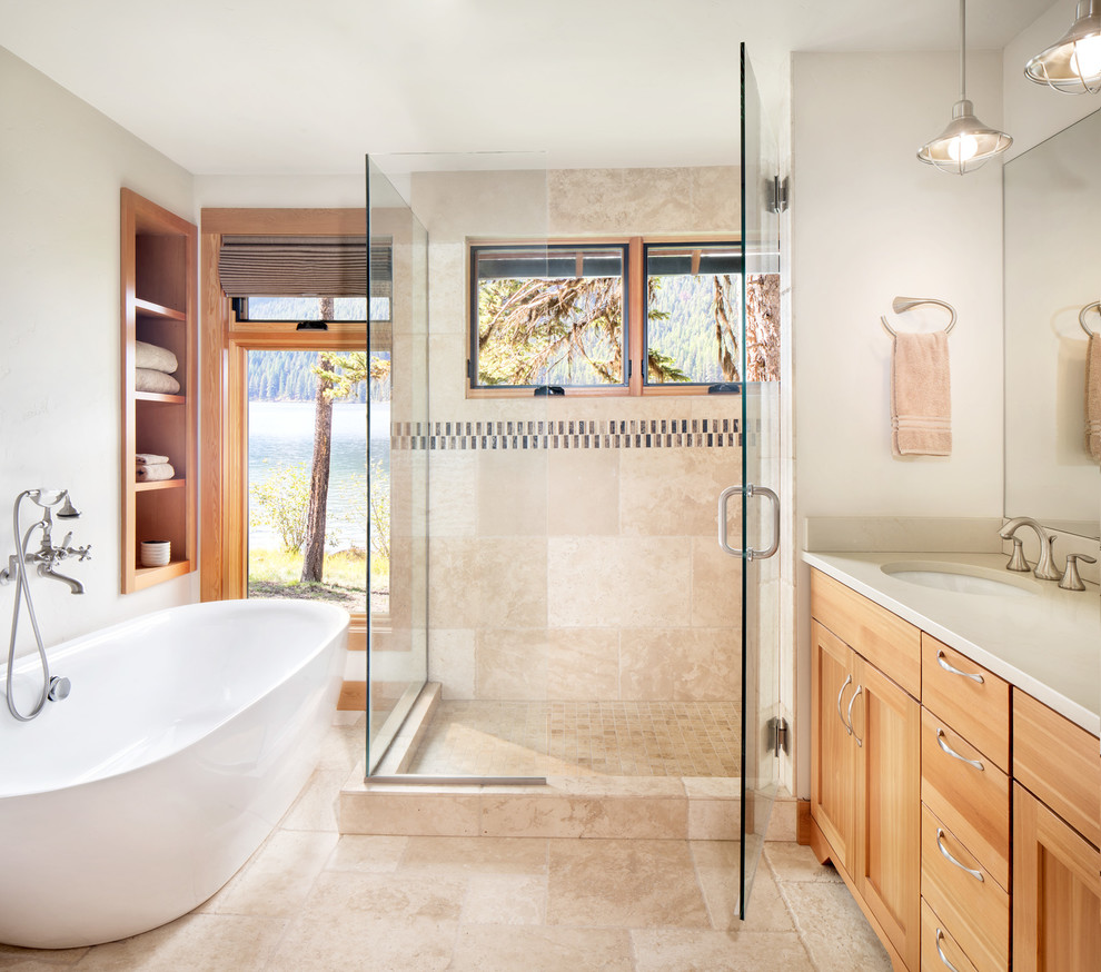 Country master bathroom in Other with shaker cabinets, light wood cabinets, a freestanding tub, beige tile, multi-coloured tile, beige walls, an undermount sink, beige floor, a hinged shower door and beige benchtops.
