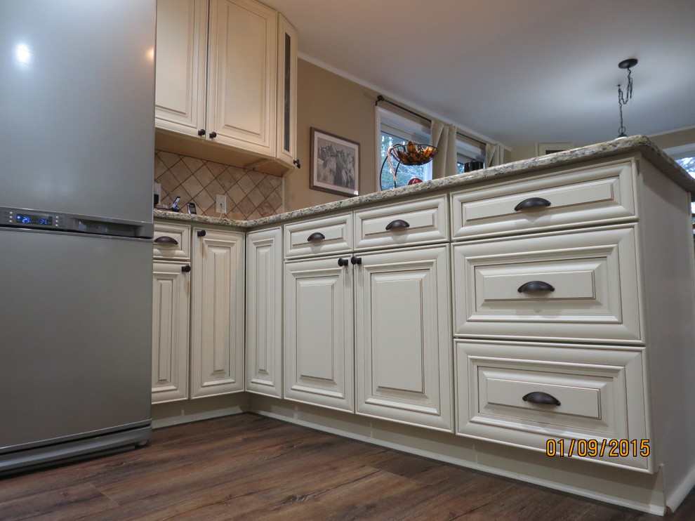 Eat-in kitchen - mid-sized u-shaped eat-in kitchen idea in DC Metro with a double-bowl sink, raised-panel cabinets, white cabinets, granite countertops, beige backsplash, porcelain backsplash and stainless steel appliances