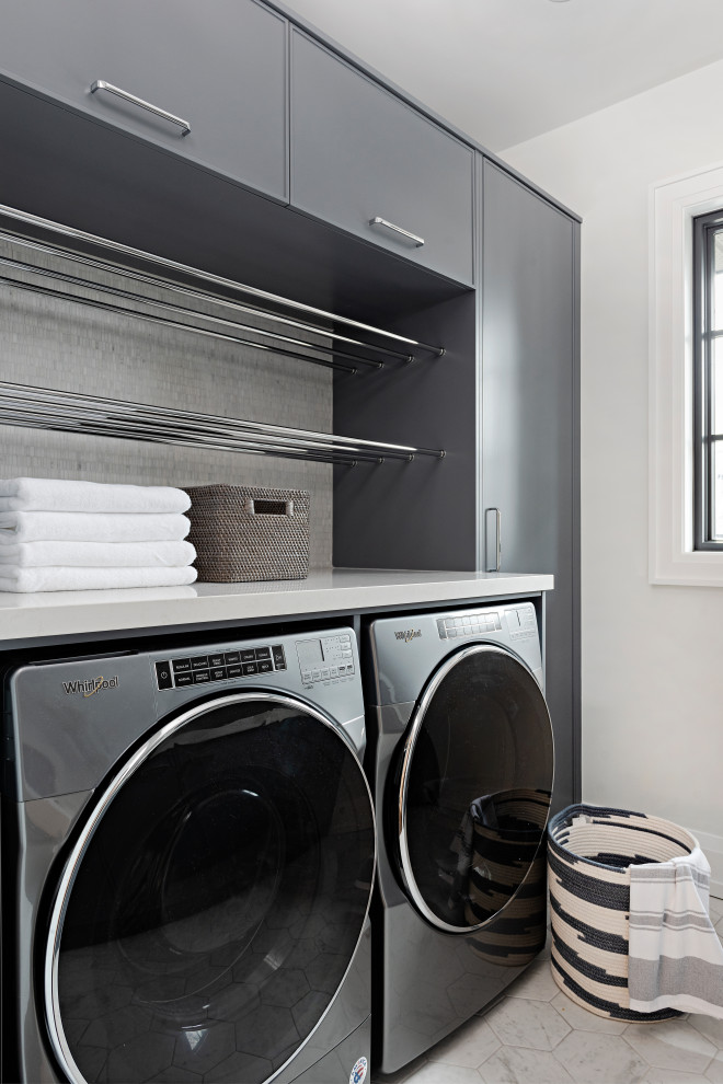 Design ideas for a mid-sized transitional galley laundry room in Toronto with recessed-panel cabinets, blue cabinets, quartz benchtops and white benchtop.