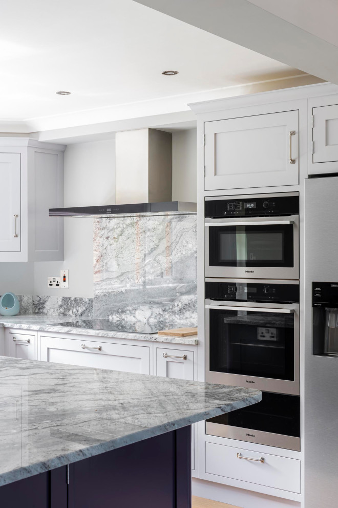 This is an example of a mid-sized traditional kitchen in Wiltshire with an undermount sink, shaker cabinets, grey cabinets, granite benchtops, grey splashback, stainless steel appliances, medium hardwood floors, brown floor and grey benchtop.
