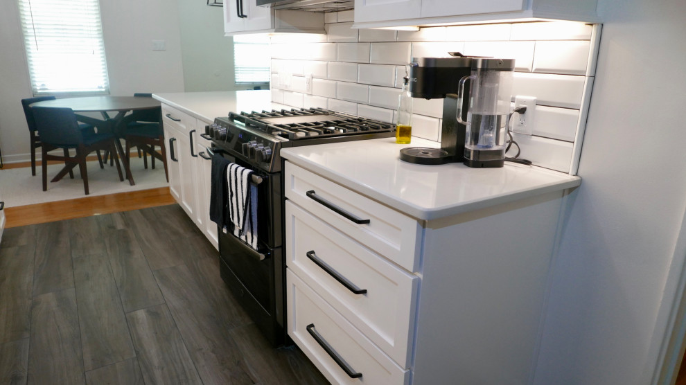Eat-in kitchen - mid-sized transitional galley porcelain tile and gray floor eat-in kitchen idea with an undermount sink, shaker cabinets, white cabinets, quartz countertops, white backsplash, subway tile backsplash, black appliances, no island and white countertops