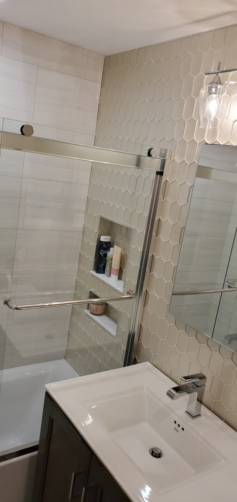 На фото: маленькая ванная комната в стиле неоклассика (современная классика) с фасадами в стиле шейкер, темными деревянными фасадами, ванной в нише, душем над ванной, раздельным унитазом, бежевой плиткой, стеклянной плиткой, бежевыми стенами, полом из керамогранита, монолитной раковиной, столешницей из искусственного камня, бежевым полом, душем с раздвижными дверями, белой столешницей, тумбой под одну раковину и встроенной тумбой для на участке и в саду