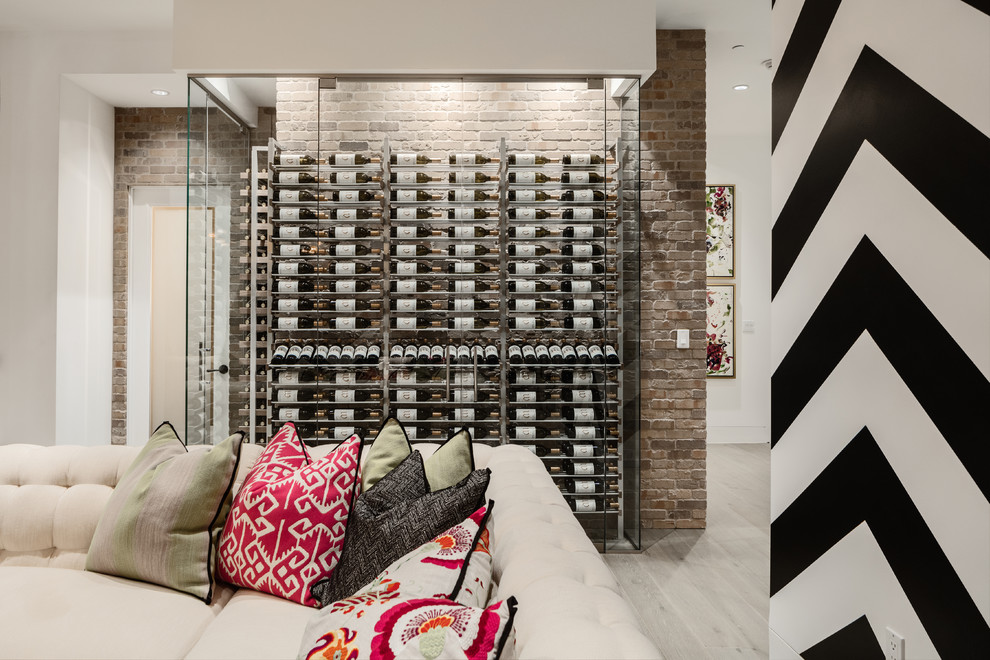 This is an example of a contemporary wine cellar in Phoenix with light hardwood floors and storage racks.