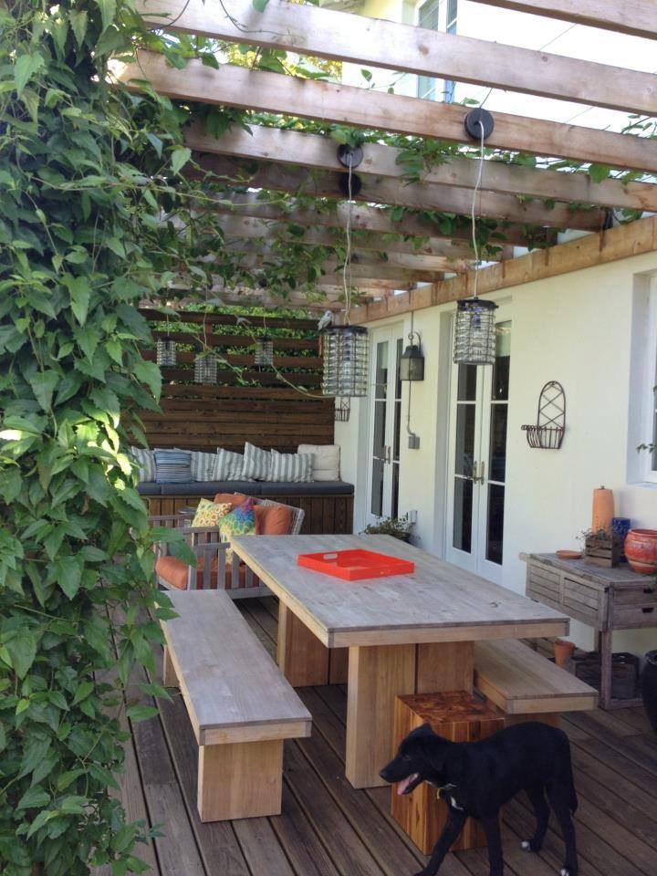 Design ideas for a mid-sized country backyard deck in Miami with a pergola.