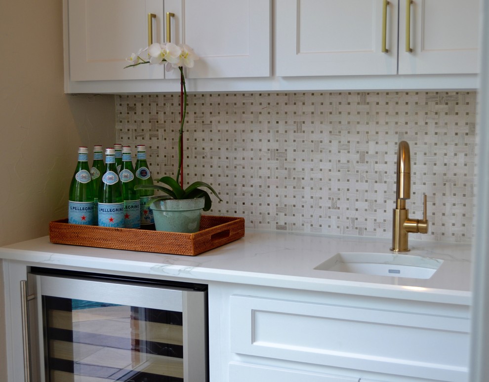 Inspiration for a small transitional single-wall wet bar in Dallas with an undermount sink, shaker cabinets, white cabinets, quartz benchtops, white splashback, mosaic tile splashback and dark hardwood floors.