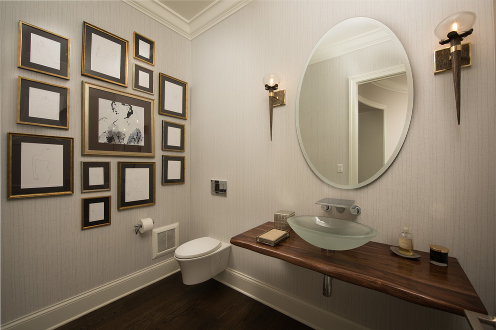 Photo of a mid-sized traditional powder room in Chicago with a wall-mount toilet, beige walls, dark hardwood floors, a vessel sink, wood benchtops, brown floor and brown benchtops.