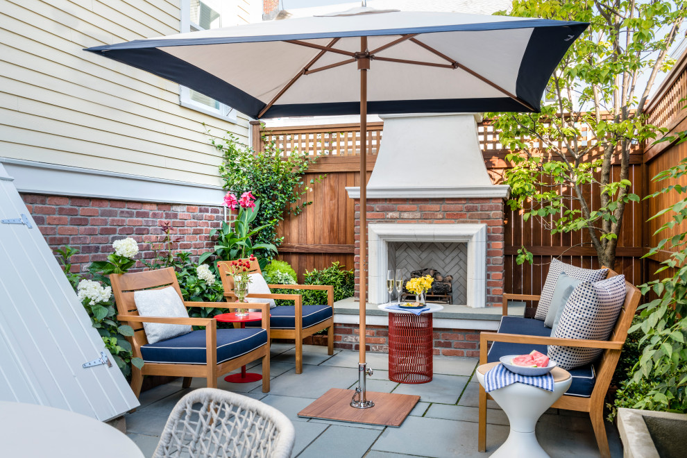 Design ideas for a mid-sized transitional side yard patio in Boston with with fireplace, natural stone pavers and no cover.