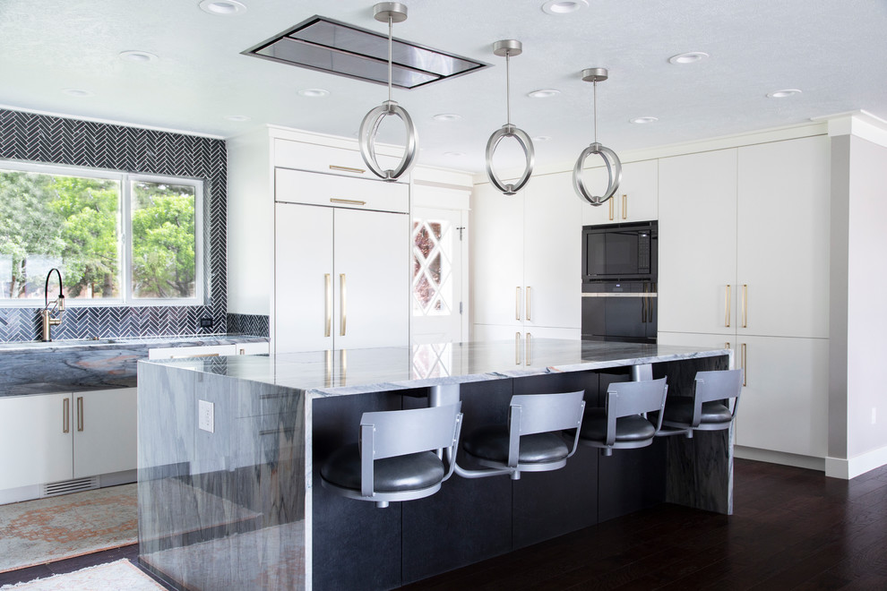 Photo of a mid-sized contemporary kitchen in Salt Lake City with flat-panel cabinets, white cabinets, black splashback, ceramic splashback, dark hardwood floors, with island, brown floor, granite benchtops, panelled appliances and multi-coloured benchtop.