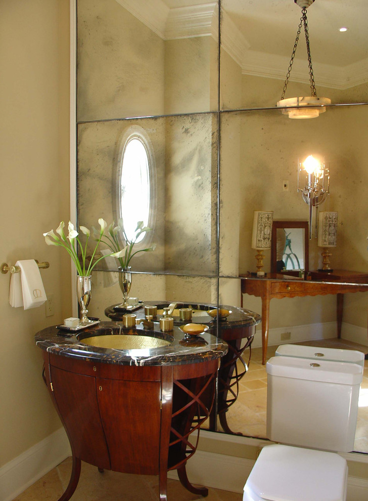 Traditional powder room in Chicago with an undermount sink, dark wood cabinets, mirror tile and furniture-like cabinets.