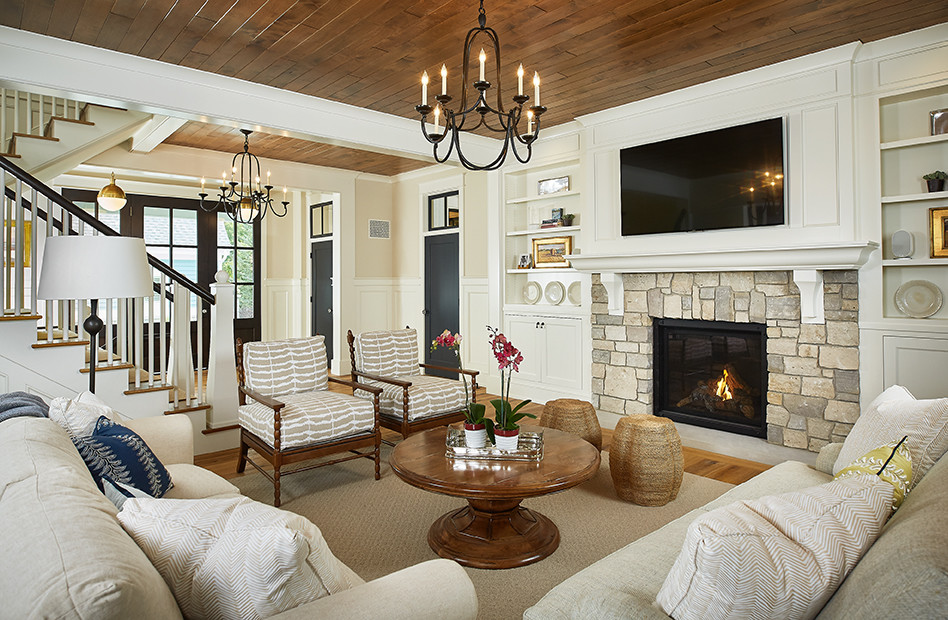 Inspiration for a mid-sized transitional open concept living room in Grand Rapids with beige walls, medium hardwood floors, a standard fireplace, a stone fireplace surround, a wall-mounted tv and brown floor.