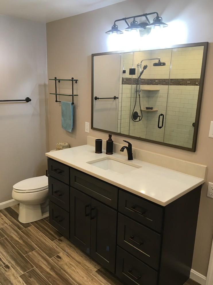 Design ideas for a small modern master bathroom in DC Metro with shaker cabinets, orange cabinets, a corner shower, a one-piece toilet, beige tile, cement tile, beige walls, cement tiles, an undermount sink, engineered quartz benchtops, brown floor, a hinged shower door and beige benchtops.