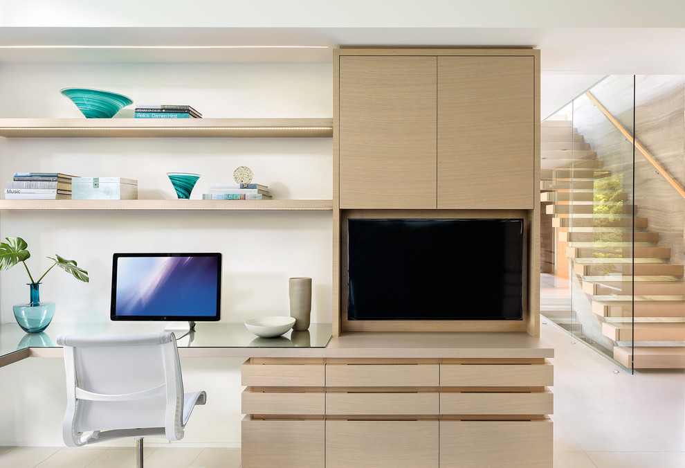 This is an example of a contemporary study room in Vancouver with white walls, a built-in desk and beige floor.