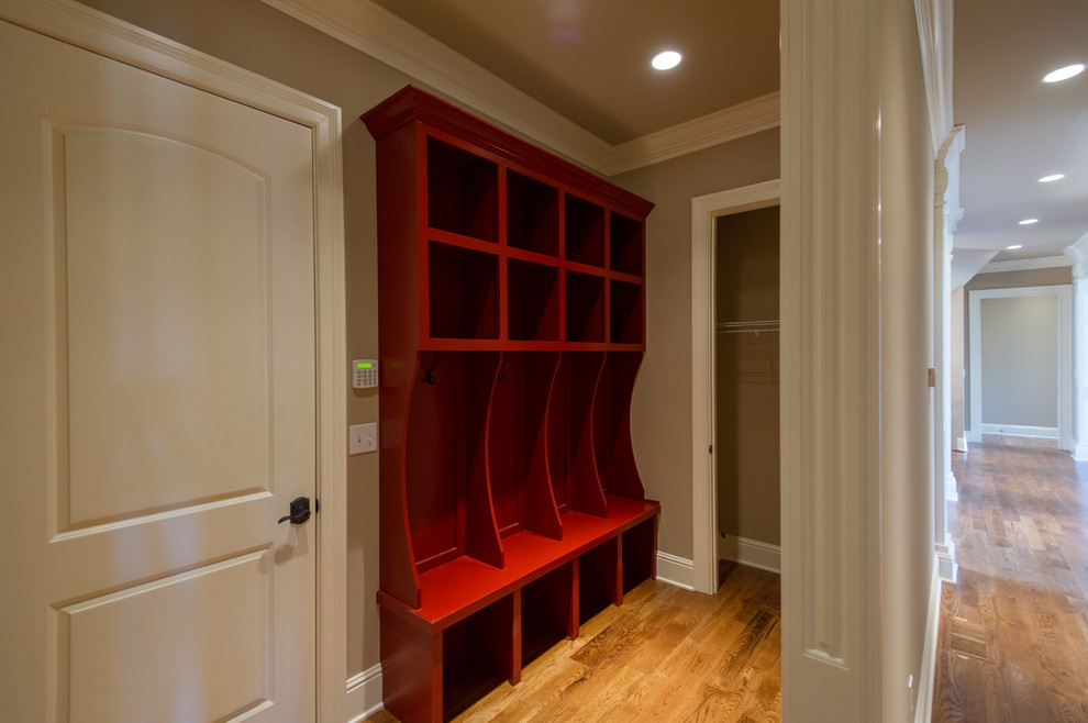 Photo of an expansive traditional utility room in Other with beige walls and medium hardwood floors.