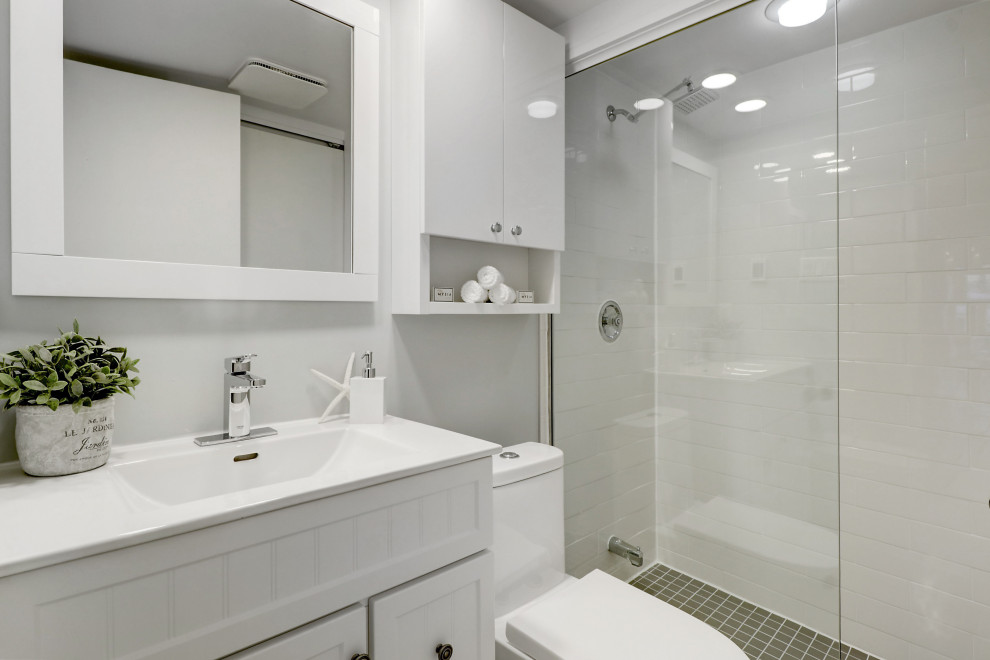 Exemple d'une petite salle de bain nature avec un placard à porte shaker, des portes de placard blanches, WC séparés, un carrelage blanc, un carrelage métro, un mur blanc, un sol en carrelage de porcelaine, un lavabo intégré, un plan de toilette en quartz modifié, un sol gris, une cabine de douche à porte coulissante, un plan de toilette blanc, meuble simple vasque et meuble-lavabo sur pied.