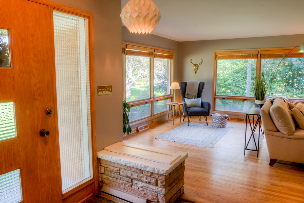 Front door - small transitional light wood floor and beige floor front door idea in St Louis with gray walls and a medium wood front door