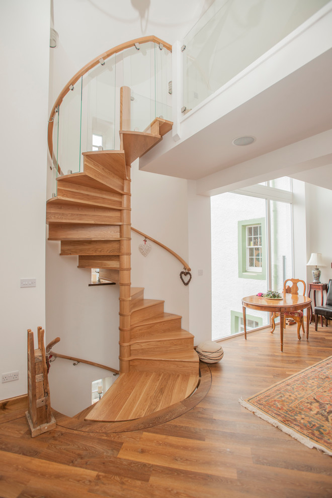 This is an example of a contemporary wood spiral staircase in Other with wood risers.