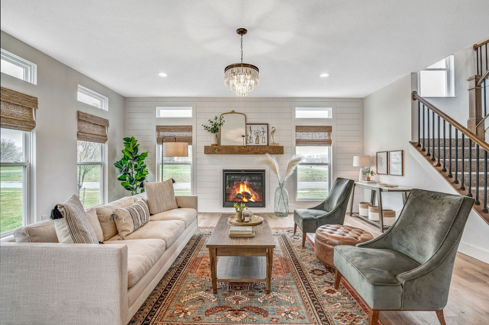 Inspiration for a large country living room in Columbus with white walls, light hardwood floors and a standard fireplace.
