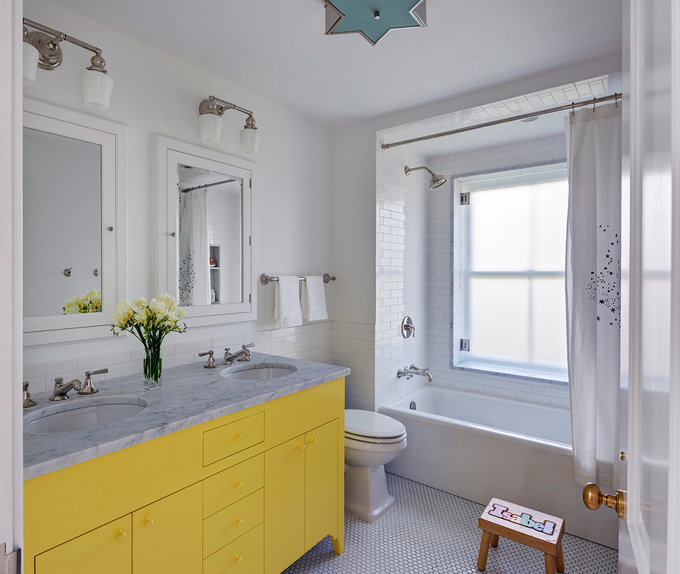 Photo of a traditional kids bathroom in New York with blue cabinets, an alcove tub, a shower/bathtub combo, white tile, subway tile, white walls, mosaic tile floors, an undermount sink, white floor and a shower curtain.