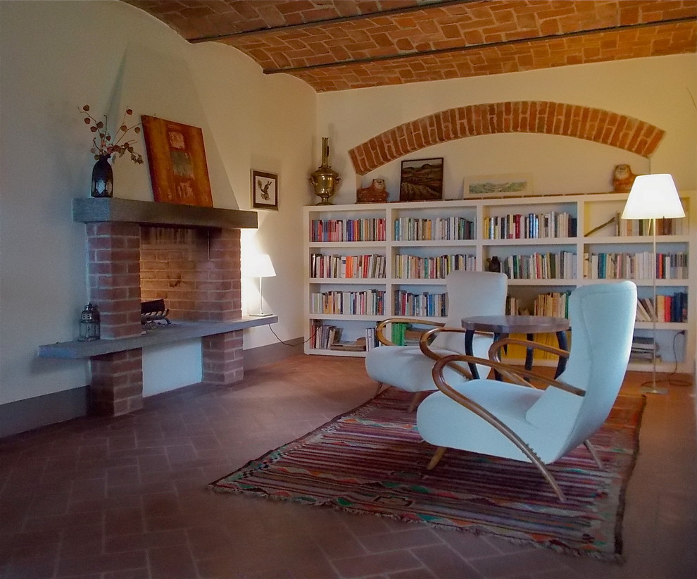 Photo of a mid-sized country open concept family room in Turin with a library, white walls, no tv and brown floor.