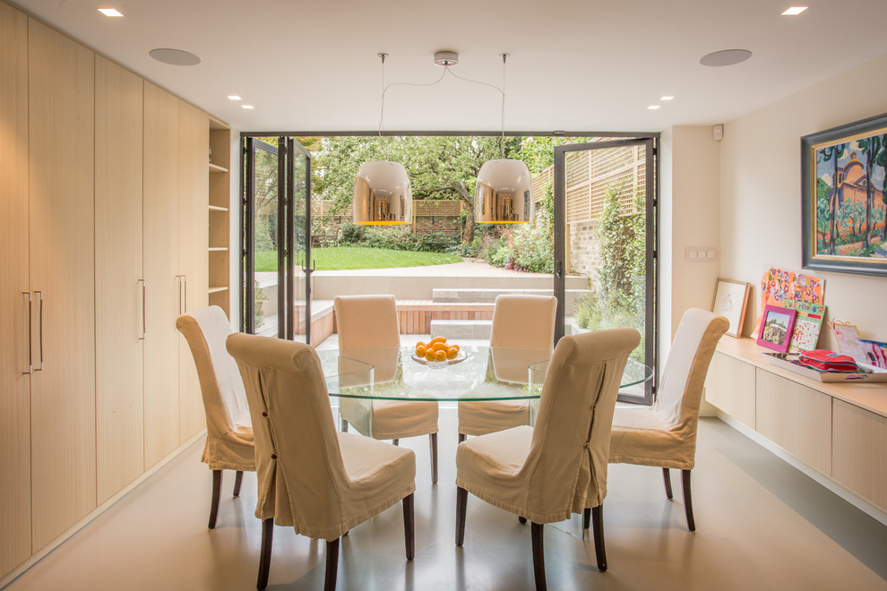 Photo of a contemporary dining room in London with white walls and beige floor.