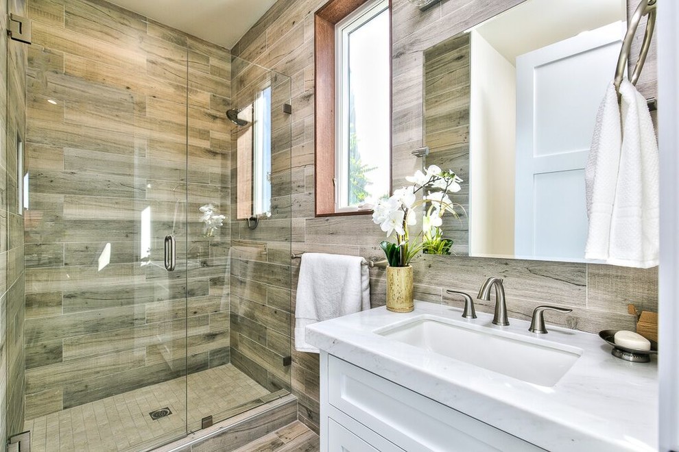 Example of a mid-sized transitional 3/4 brown tile, gray tile and porcelain tile porcelain tile and brown floor alcove shower design in Orange County with shaker cabinets, white cabinets, brown walls, an undermount sink, marble countertops and a hinged shower door