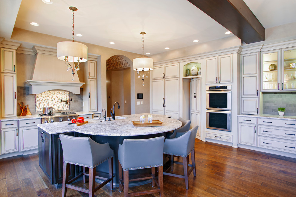 Inspiration for a large transitional single-wall dark wood floor and brown floor enclosed kitchen remodel in Denver with an undermount sink, recessed-panel cabinets, beige cabinets, granite countertops, gray backsplash, subway tile backsplash, paneled appliances, an island and gray countertops