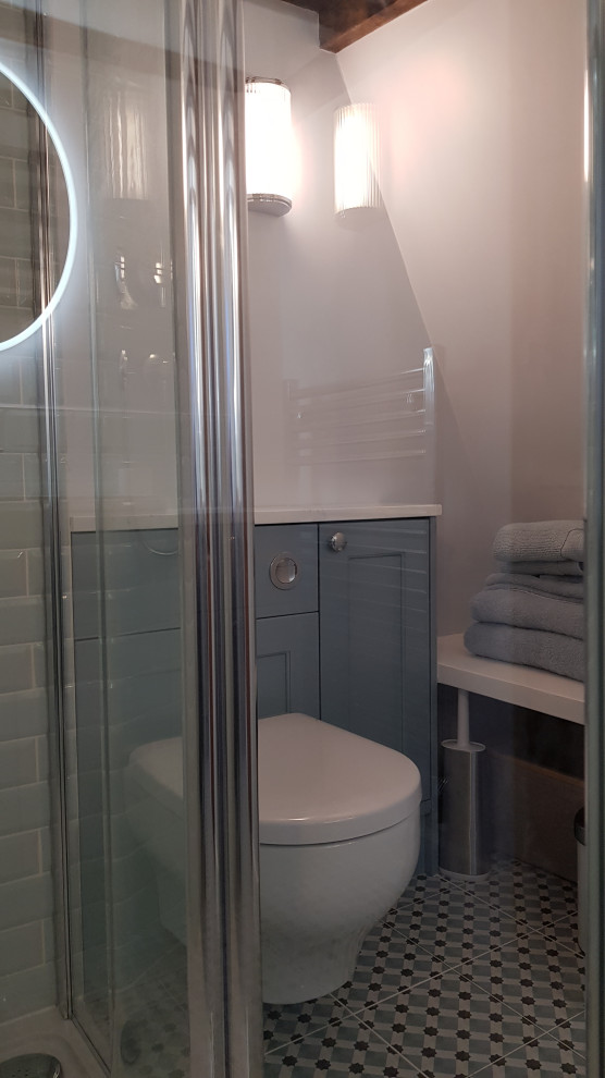 Exempel på ett litet klassiskt vit vitt en-suite badrum, med skåp i shakerstil, blå skåp, en öppen dusch, en vägghängd toalettstol, blå kakel, keramikplattor, blå väggar, klinkergolv i keramik, ett nedsänkt handfat, bänkskiva i akrylsten, blått golv och med dusch som är öppen