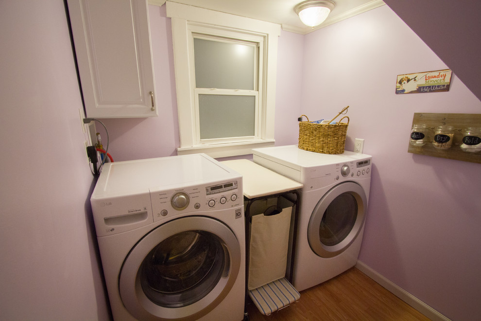 Bild på en liten vintage tvättstuga enbart för tvätt, med lila väggar och en tvättmaskin och torktumlare bredvid varandra