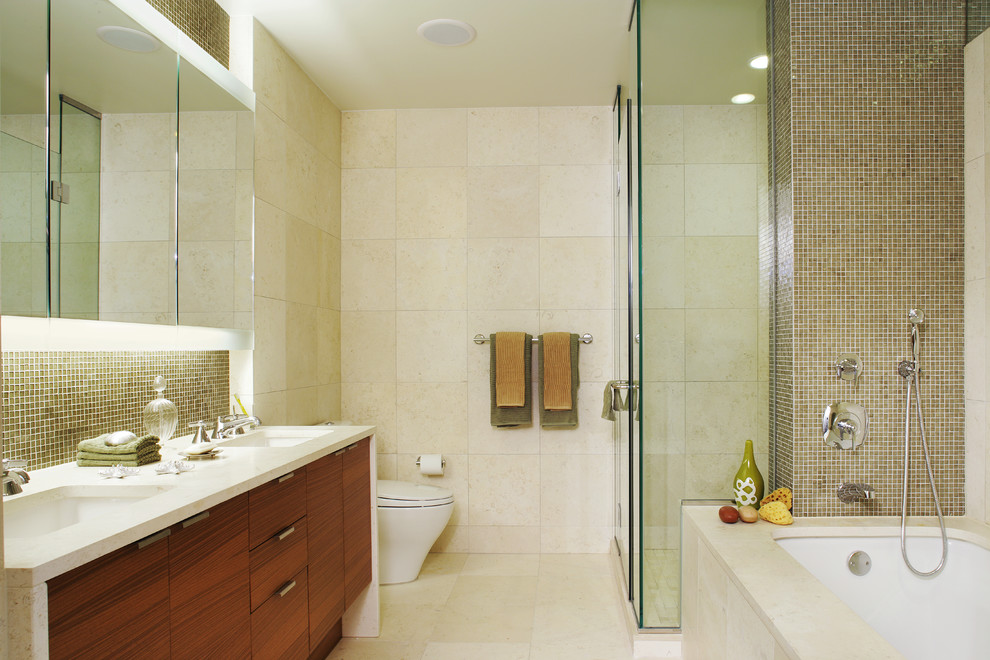 Photo of a contemporary bathroom in New York with an undermount sink, flat-panel cabinets, dark wood cabinets, an undermount tub, a corner shower and beige tile.