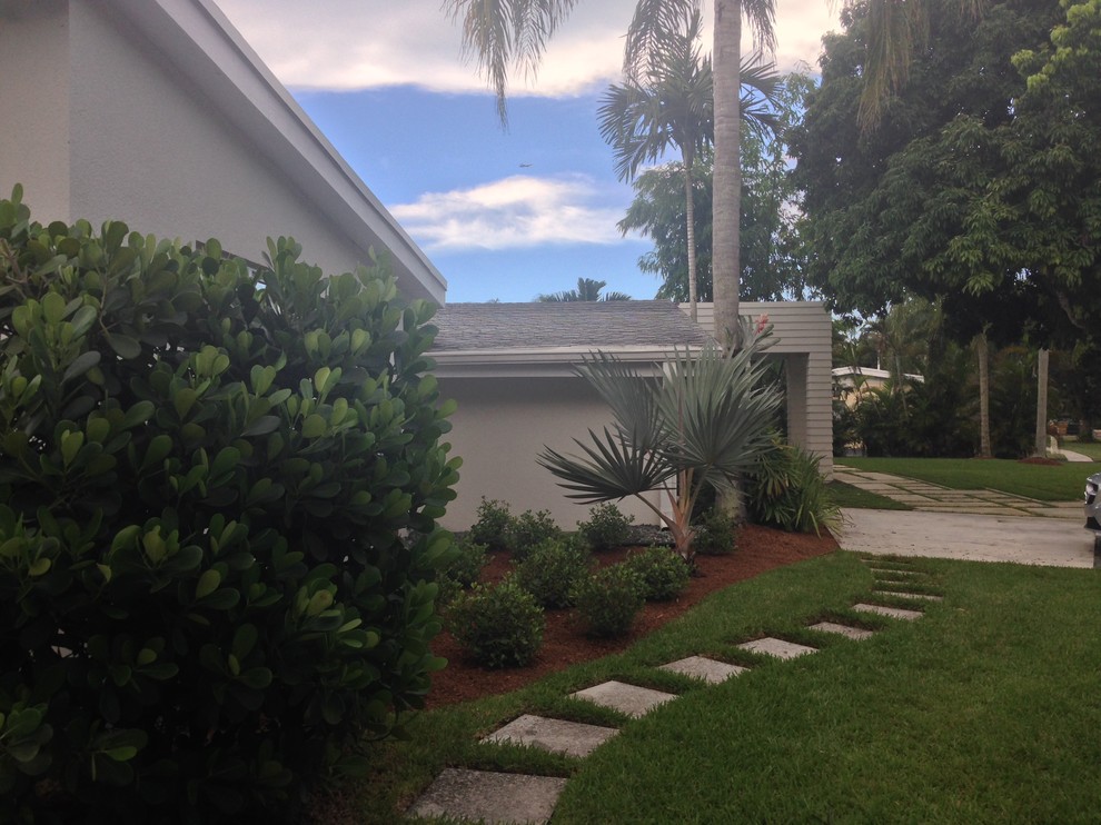 Inspiration for a mid-sized modern front yard full sun formal garden in Miami with a garden path and concrete pavers.
