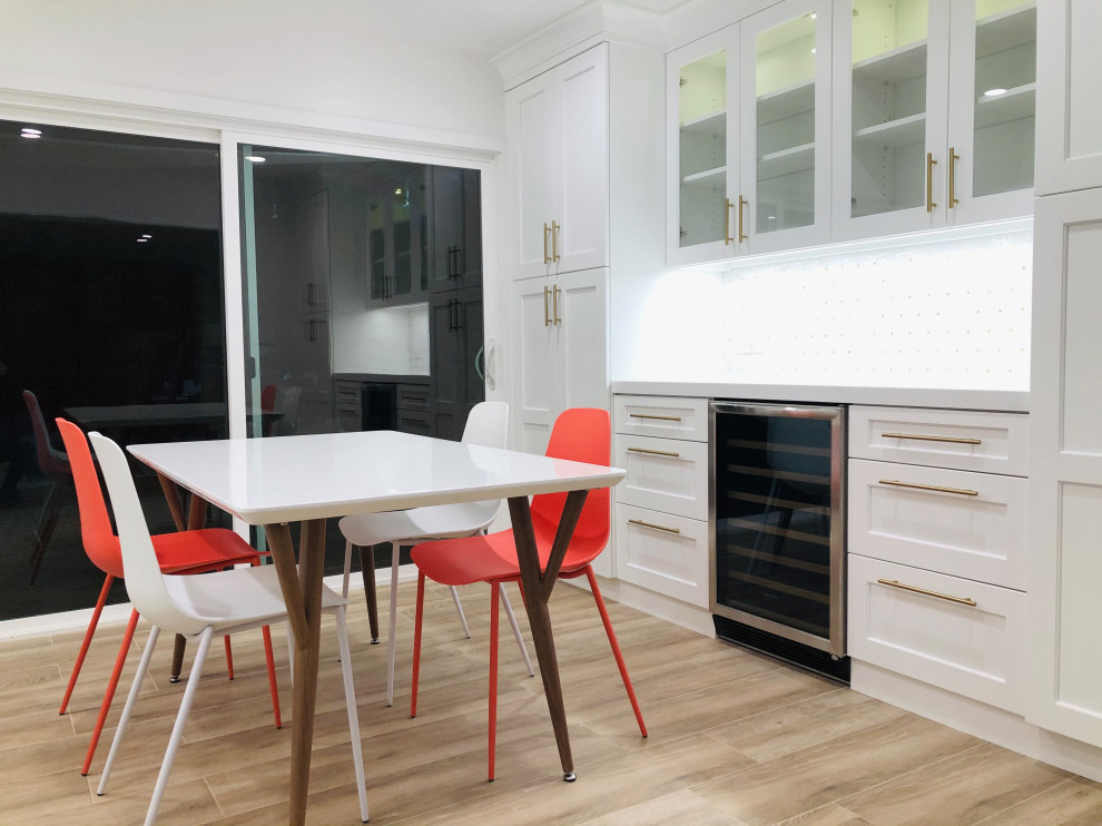 Eat-in kitchen - mid-sized transitional l-shaped medium tone wood floor and brown floor eat-in kitchen idea in San Francisco with a farmhouse sink, recessed-panel cabinets, white cabinets, quartz countertops, white backsplash, mosaic tile backsplash, stainless steel appliances, a peninsula and white countertops