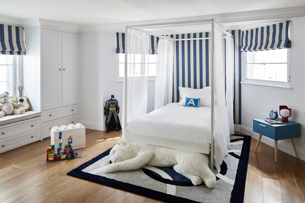 Design ideas for a large transitional kids' bedroom for kids 4-10 years old and boys in London with white walls, medium hardwood floors and brown floor.