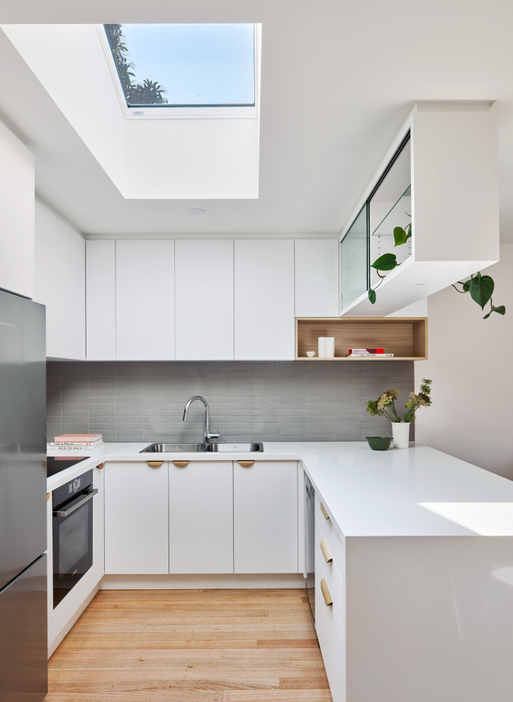 Kleine Moderne Küche in U-Form mit Mineralwerkstoff-Arbeitsplatte und weißer Arbeitsplatte in Melbourne
