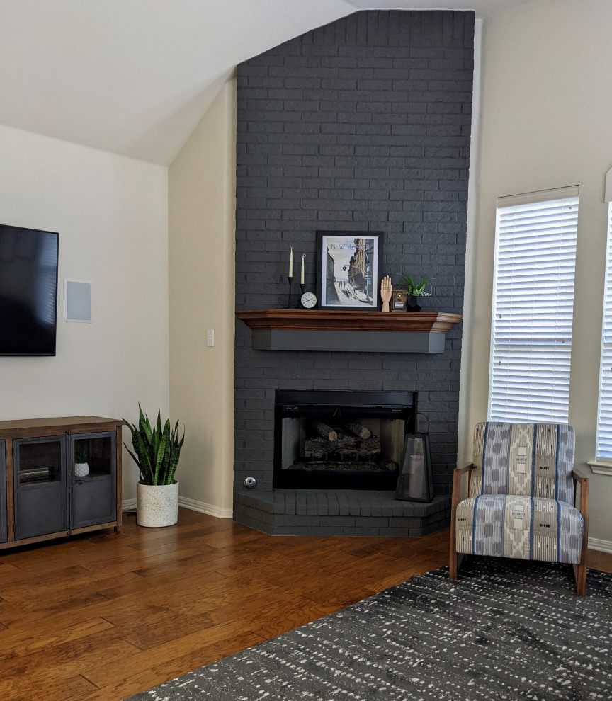 Пример оригинального дизайна: большая открытая гостиная комната в стиле ретро с бежевыми стенами, паркетным полом среднего тона, угловым камином, фасадом камина из кирпича, телевизором на стене, коричневым полом и сводчатым потолком