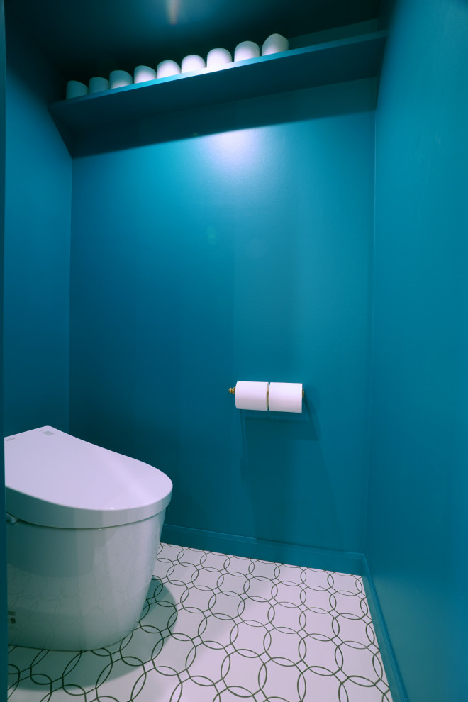 東京都下にあるコンテンポラリースタイルのおしゃれなトイレ・洗面所 (一体型トイレ	、青い壁、セラミックタイルの床、白い床) の写真