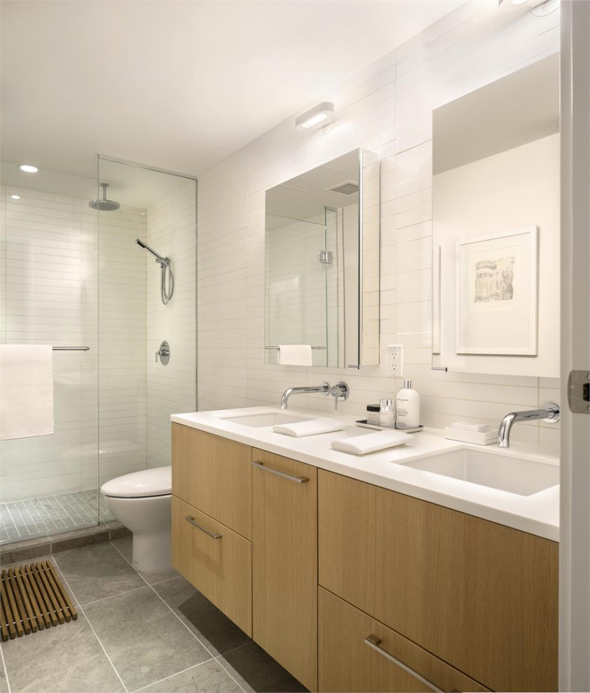 Photo of a mid-sized contemporary master bathroom in Vancouver with flat-panel cabinets, beige cabinets, a curbless shower, a one-piece toilet, white tile, porcelain tile, white walls, mosaic tile floors, an integrated sink, granite benchtops, grey floor, a sliding shower screen, white benchtops, a double vanity and a floating vanity.