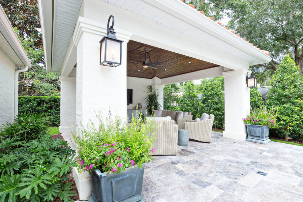 Photo of a mid-sized traditional backyard patio in Orlando with a container garden and natural stone pavers.