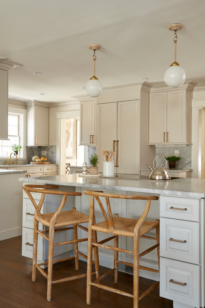 Photo of a traditional kitchen in Boston with shaker cabinets, beige cabinets, grey splashback, stone slab splashback, medium hardwood floors, with island and grey benchtop.