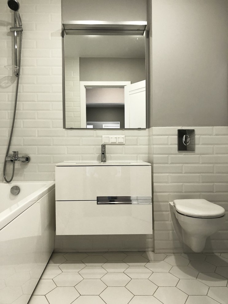 Mid-sized scandinavian master bathroom in Moscow with white cabinets, a freestanding tub, a shower/bathtub combo, a wall-mount toilet, white tile, white walls, porcelain floors, a pedestal sink, white floor and a shower curtain.