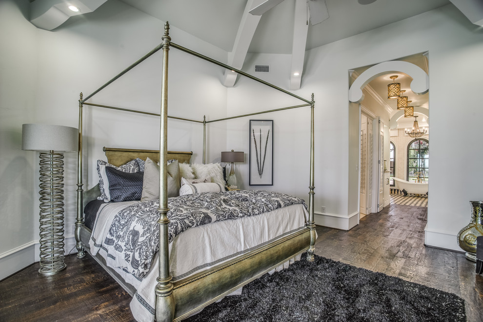 This is an example of a large traditional master bedroom in Austin with dark hardwood floors and white walls.