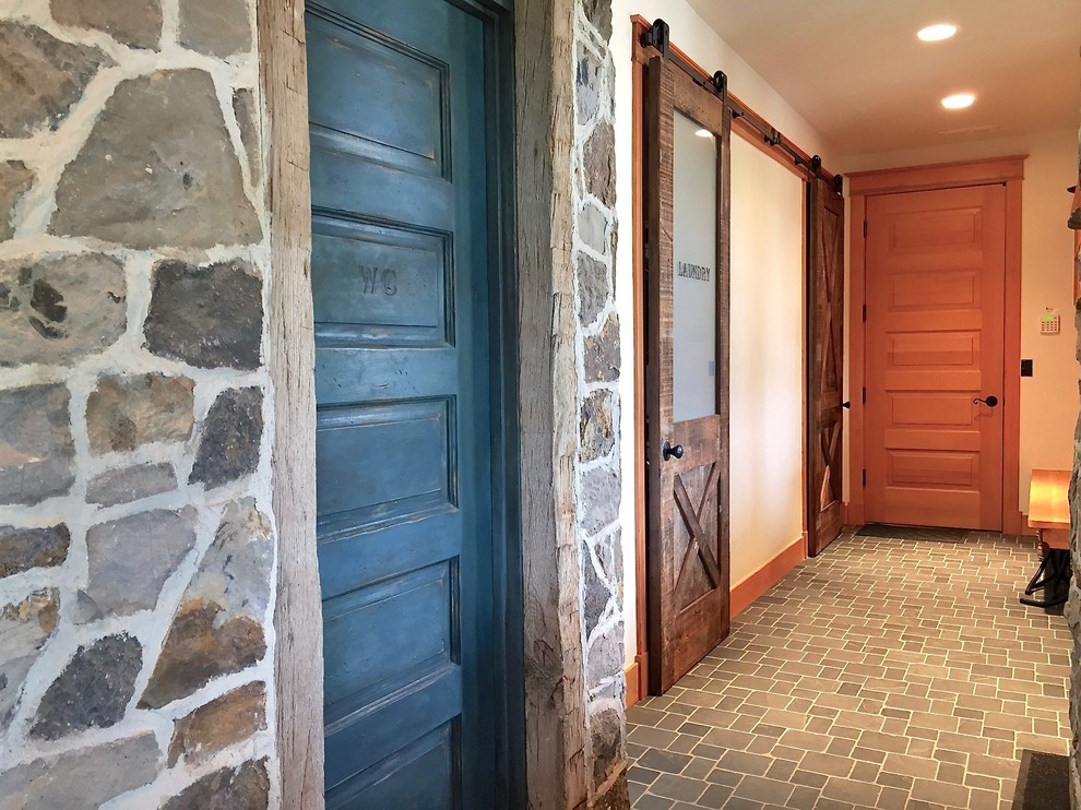 Photo of a mid-sized country hallway in Denver with beige walls and slate floors.