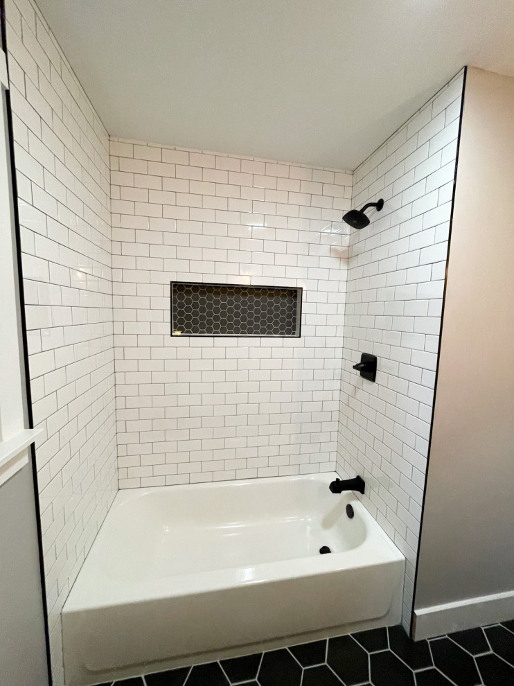 Design ideas for a mid-sized modern master bathroom in Detroit with shaker cabinets, dark wood cabinets, a drop-in tub, a shower/bathtub combo, a one-piece toilet, white tile, subway tile, grey walls, porcelain floors, a drop-in sink, concrete benchtops, black floor, a shower curtain, grey benchtops, a niche, a single vanity and a freestanding vanity.
