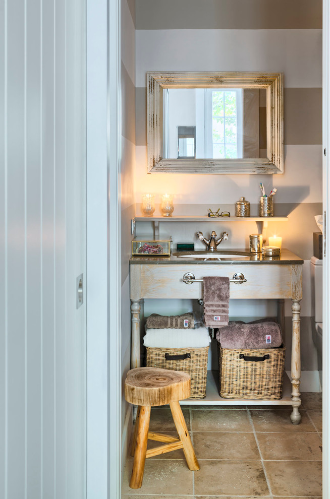 Photo of a small scandinavian powder room in Madrid with furniture-like cabinets, light wood cabinets, multi-coloured walls, terra-cotta floors, an undermount sink and solid surface benchtops.