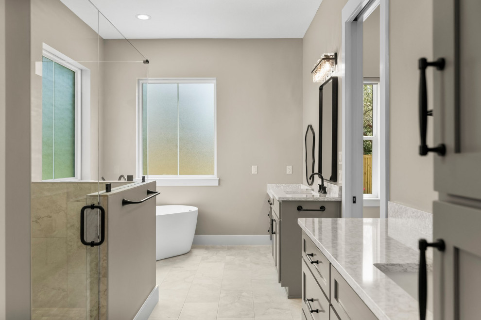 Freestanding bathtub - mid-sized craftsman master beige tile and porcelain tile porcelain tile, beige floor and double-sink freestanding bathtub idea with shaker cabinets, beige cabinets, a two-piece toilet, beige walls, an undermount sink, quartzite countertops, a hinged shower door, beige countertops and a built-in vanity
