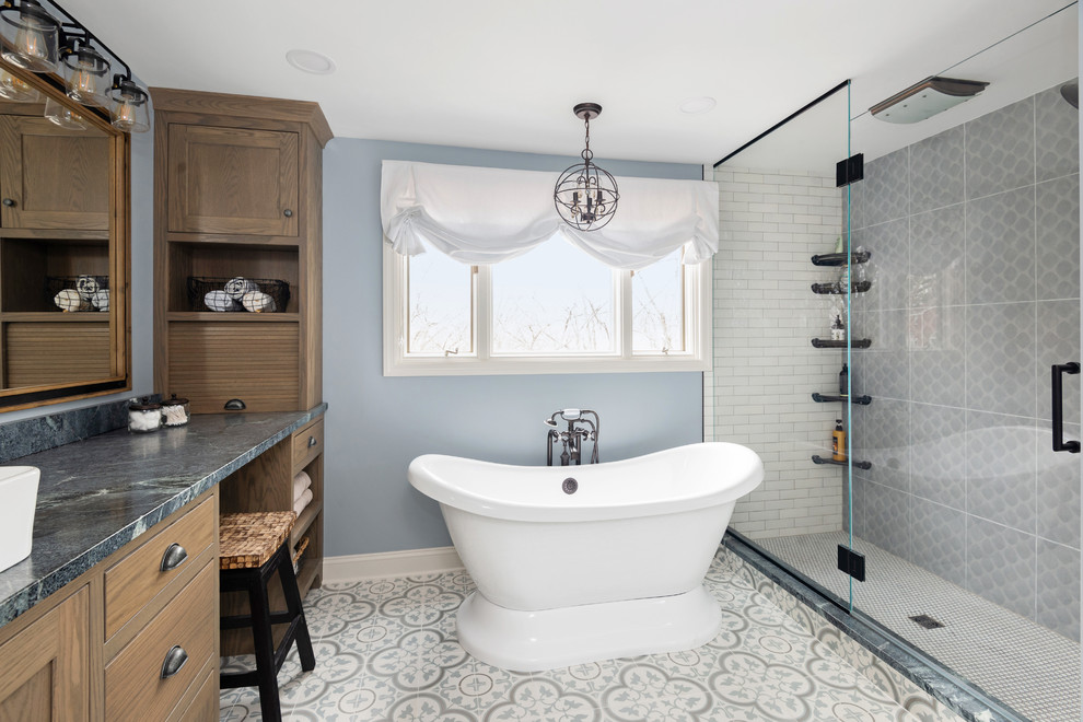 Transitional bathroom in Other with shaker cabinets, medium wood cabinets, a freestanding tub, gray tile, blue walls, multi-coloured floor, a hinged shower door and grey benchtops.