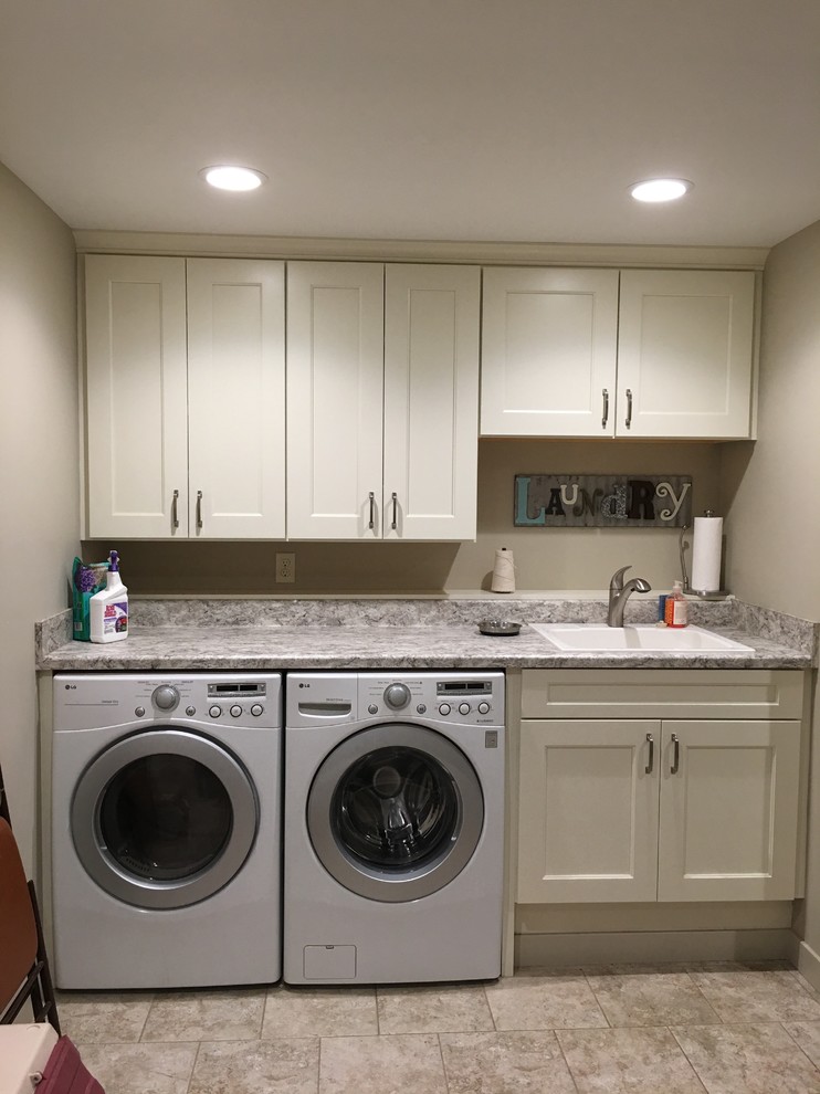 Inspiration for a small traditional single-wall dedicated laundry room in Grand Rapids with white cabinets, laminate benchtops, ceramic floors, a side-by-side washer and dryer, beige floor, shaker cabinets, a drop-in sink and grey walls.