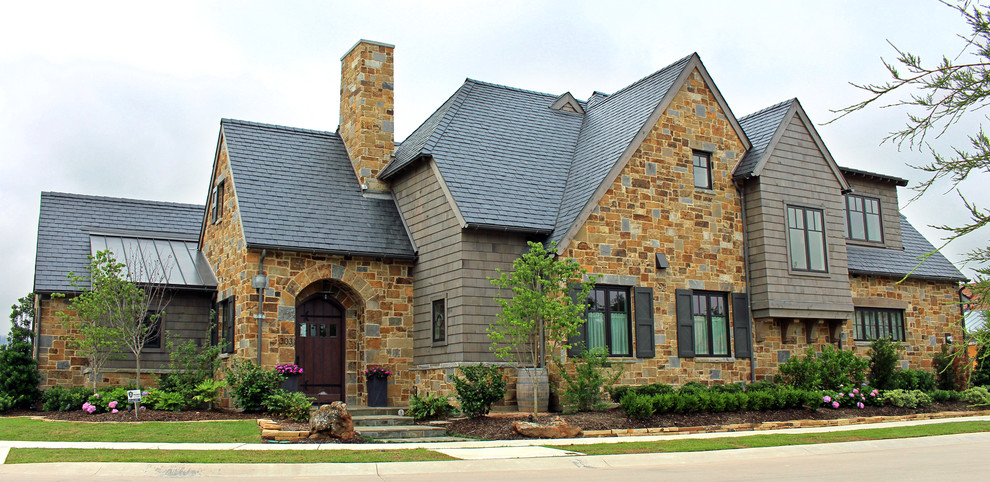 Inspiration for a large traditional two-storey duplex exterior in Dallas with stone veneer.