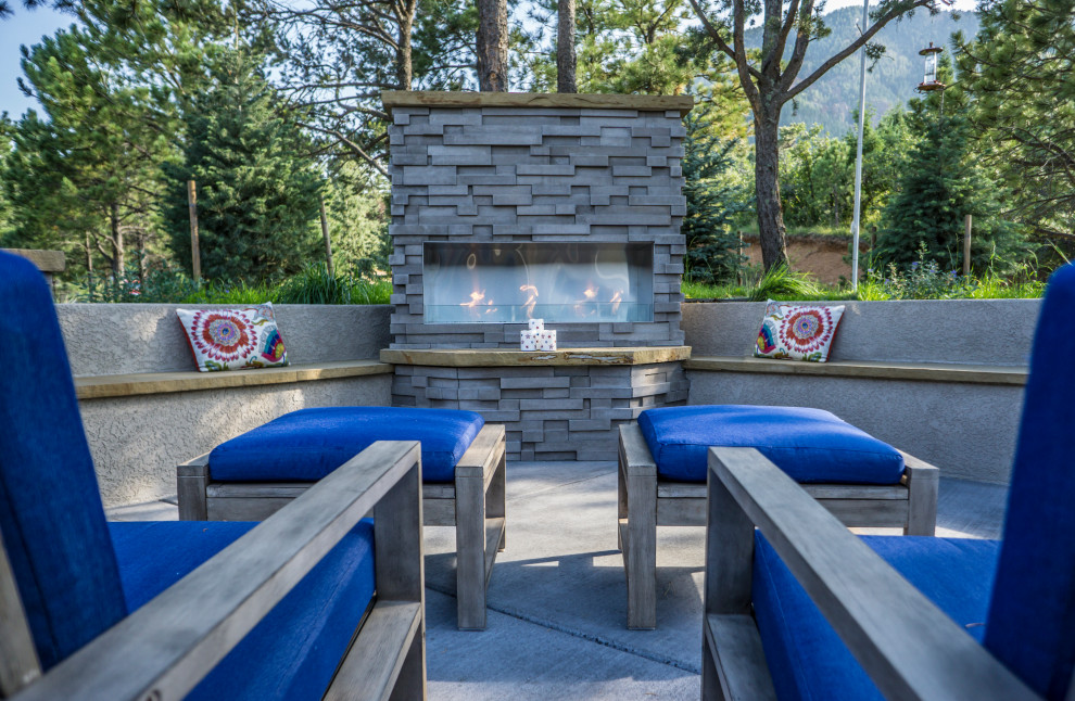 Medium sized contemporary front patio in Denver with a fireplace, concrete slabs and no cover.