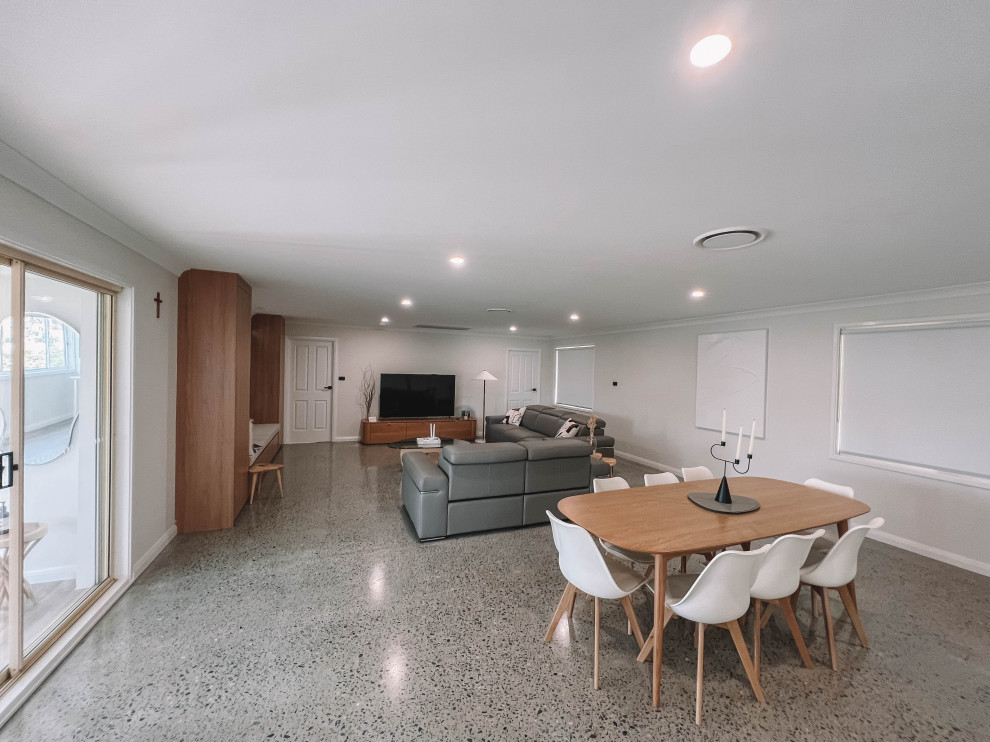 Inspiration for a mid-sized scandinavian open plan dining in Newcastle - Maitland with white walls, concrete floors, grey floor, timber and wood walls.