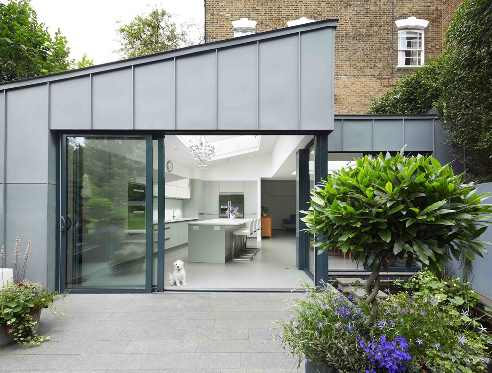 Design ideas for a gey contemporary house exterior in London with metal cladding and a lean-to roof.